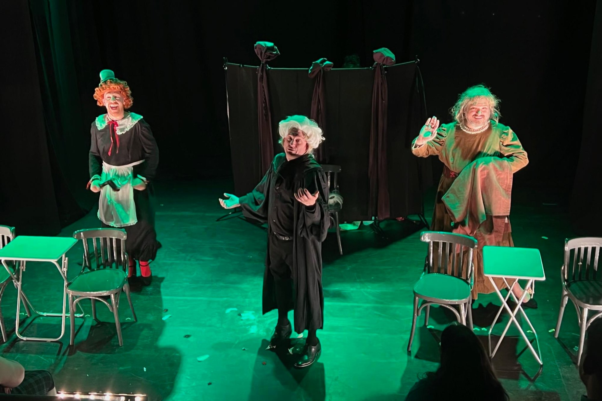 Three performers in green light during Lottie Platchett Took a Hatchet, Edinburgh Fringe 2022